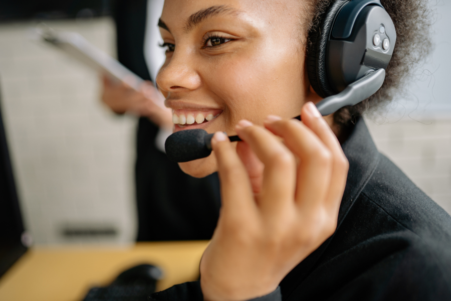 Agente de atención al cliente con auriculares atendiendo a usuarios en un servicio de soporte empresarial.